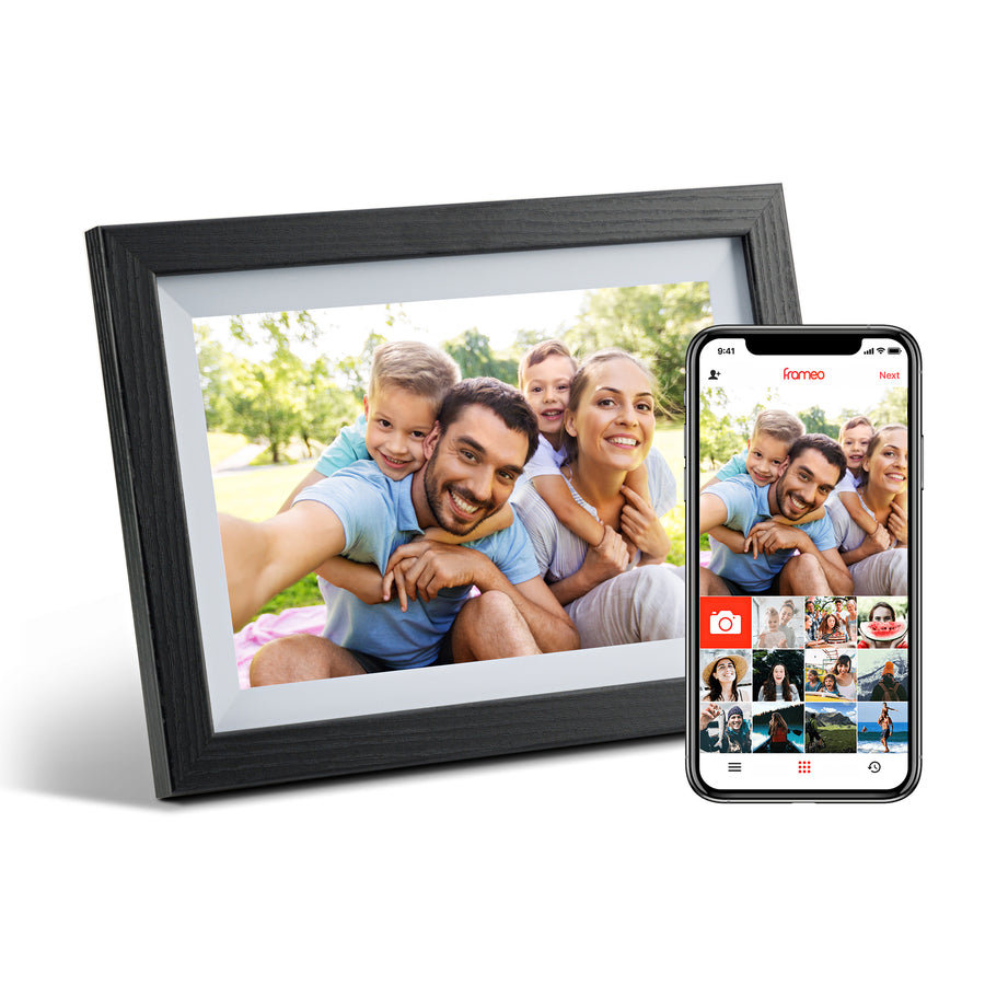 Digital photo frame displaying a family photo next to a smartphone showing the companion app with photo gallery.